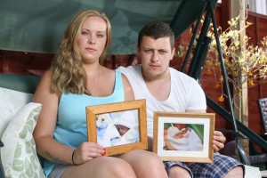 Emma Jones and Christopher Goodger with photos of their sons Tyler and Riley.